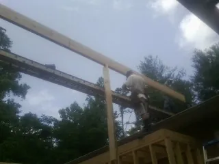 Carpenter setting a ridge beam over a new addition frame — Ice Dam Removal by Roofing Brothers in Wentworth