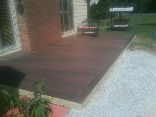 Freshly stained wood deck built against a brick home in Wentworth