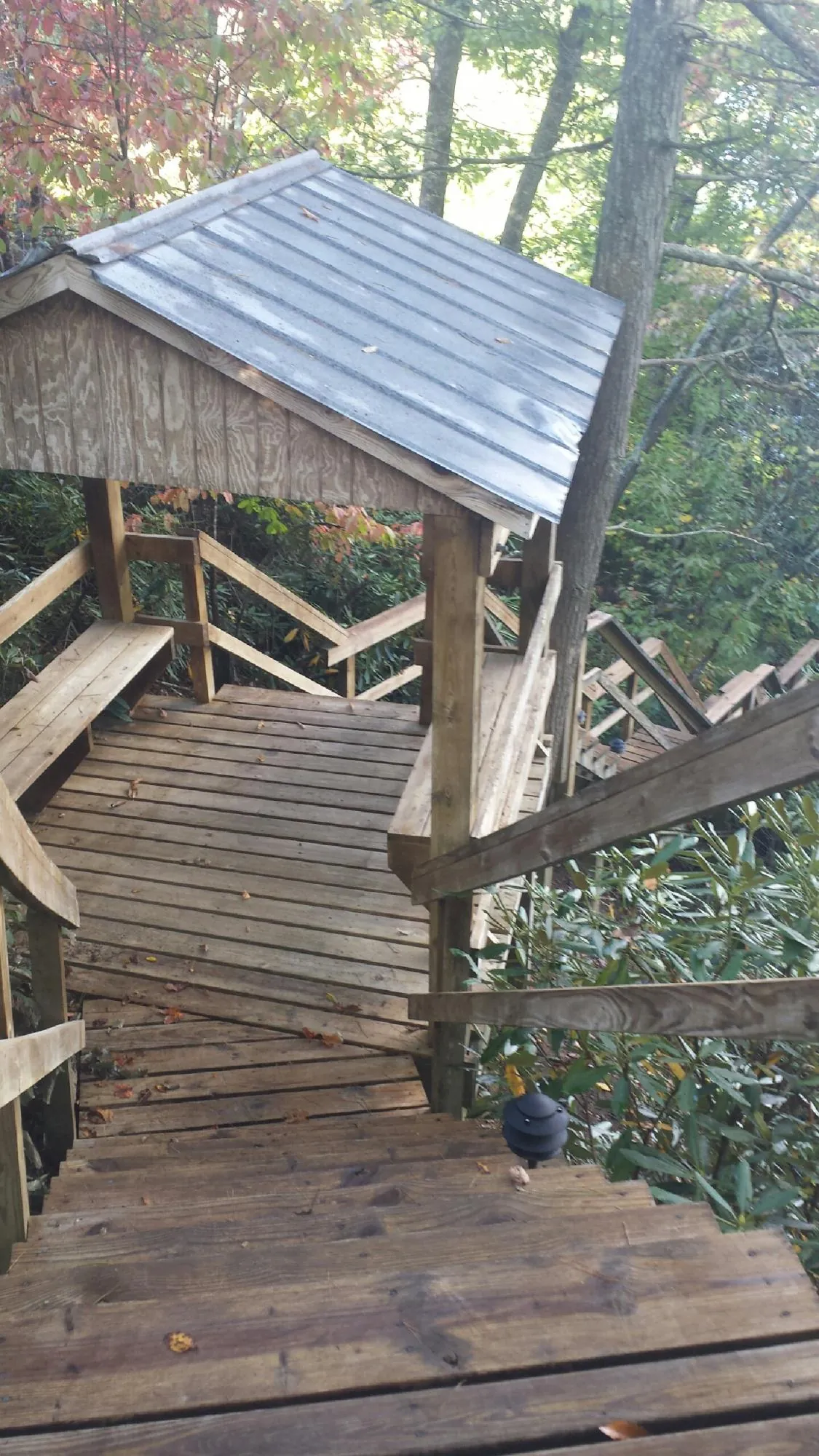 Metal roofed shelter over wooden steps on a wooded walkway — Skylight Repair & Installation work by our crew in Wentworth